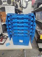 Front view of six stacked blue storage totes showing lids and handles