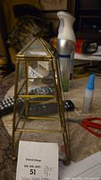 3-tier glass and brass terrarium, standing upright showing all three tempered glass shelves and brass frame, vintage style.