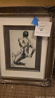 Full front view of the framed charcoal drawing of male nude figure.