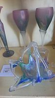 View of Murano glass basket and 3 Rueven glassware pieces on shelf