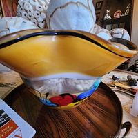 Front angle of large glass bowl showing multicolor abstract design and part of the decorative balls inside.