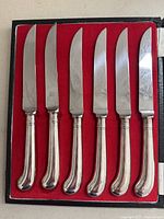 Set of 6 Birks dinner cutting knives with silver-plated handles in original box with red velvet lining.