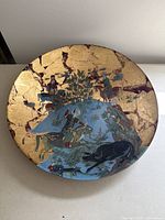 Top view of the round glass decorative bowl showing the full Persian hunting scene painted in the center and gold leaf background.