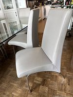 Front and side view of two chairs showing seat cushion, backrest, and curved metal legs.