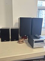 Photo showing the two Panasonic speakers, two larger PSB speakers, Panasonic stereo unit, remote control, and speaker wires.