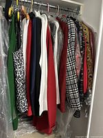 Photo showing multiple women's jackets and tops hanging on a rack including colorful and patterned pieces.