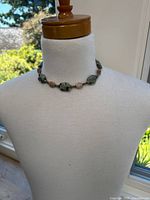 Full view of necklace displayed on mannequin showing length and bead arrangement.