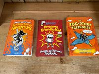 Front cover photo showing three hardcover children's books: two from Rowley Jefferson's Awesome Friendly Adventure series by Jeff Kinney and one The 104-Story Treehouse by Andy Griffiths.