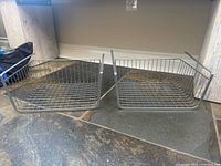 Two metal wire rack organizers positioned side by side, showing their size and structure with open wire grid design and a 1-inch hanger at the top.