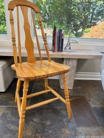 Small wooden chair placed near window, showing front and side view