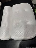 Top view of white mesh bath pillow showing front padded surface with textured mesh fabric.