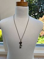 Full view of one skeleton key necklace on a mannequin showing length and pendant detail