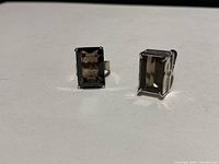 Both silver rings displayed side by side showing large rectangular smoky quartz stones.