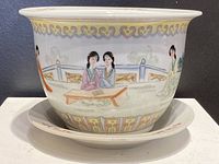 Front and side view of Chinese Famille Rose ceramic jardiniere on matching saucer, showing detailed hand-painted women figures in garden setting.