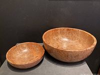 Two wooden bowls made from maple burl placed side by side showing size difference