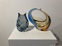 Photo showing front view of blue zigzag Murano glass vase and blue-amber curved glass basket