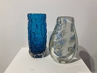 Two vases side by side on white surface
