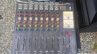 Full view of the vintage interface mixing sound board showing all 8 channel faders, multiple colored control knobs, and various input/output ports.