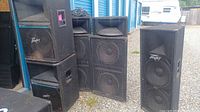 Five speaker cabinets stacked outdoors, including PV215, SP4, SP2XT
