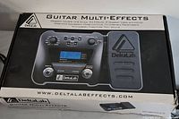 Photo showing the original box of the DeltaLab Guitar Multi-Effects pedal with product image and branding.