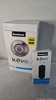 Photo showing the Kwikset Kevo smart lock box with the lock image and Bluetooth compatibility noted alongside the key fob box.