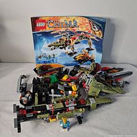 Photo showing partially assembled Lego Legends of Chima set 70227 and instruction manual with set image.