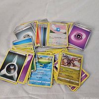 Photo showing assorted Pokémon cards including character and energy cards.