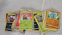 Assorted Pokémon cards spread showing Yellow border cards with various Pokémon and types including Yanma, Venipede, and Wigglytuff.