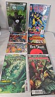 Photo showing eight assorted comic books standing upright, including Green Lantern Corps, Wolverine, Avengers, Captain Marvel, Red Skull, and Deadpool comic books.