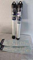 Two clear tubes containing Salt Life decals, with two white vinyl decals displayed below.