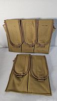 Front view of two tan ammunition magazine pouches; one bigger with three flap compartments and one smaller with two flap compartments.