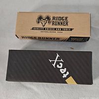 Two boxed knives, one Ridge Runner and one Tekton, unopened and in original packaging.