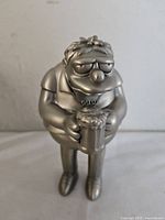 Front view of the pewter Barney Gumble figurine showing his facial expression and beer mug.