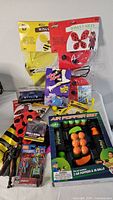 Photo of packaged costume wings (bee and ladybug) along with air popper set, rubber duck, and some smaller toys.