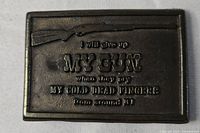 Front view shows the embossed rifle and text on the dark metal buckle.