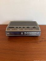 Front view of General Electric AM/FM digital alarm clock radio showing digital time display and analog radio tuner below.