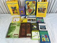 All items laid out on white table including tarot decks, card sets, and books.