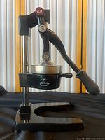 Front view of the Zulay Kitchen manual heavy duty juicer, showing its black metal frame, lever handle and base.