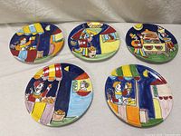 Overview of five colorful hand-painted Italian pottery plates with various market scenes.