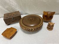 Full view of all five vintage hand-carved wooden items arranged on a white surface: owl figures, rustic bowl, folk wooden box, and tray.