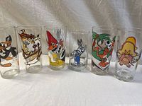 Six vintage Looney Tunes collector glasses displayed side by side showing character artwork on each glass.