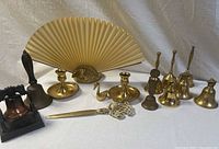 Full view of all lot items including 8 bells, candleholders, swan dish, letter opener, phone replica and decorative fan