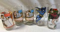 Five clear collectible glasses arranged in a row showing the Star Wars and DC Comics characters illustrated on them.