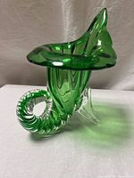 Front angle view of green glass cornucopia vase showing spiral clear base and flared top