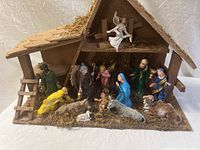 Front view of the full nativity scene including stable, figures of Mary, Joseph, baby Jesus, three wise men, shepherd, angel, and animals.