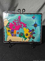 Front view of the coin set with colorful Canadian map featuring 13 embedded quarters representing provinces and territories.