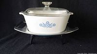Side view of white ceramic casserole dish with Cornflower Blue design on warming tray