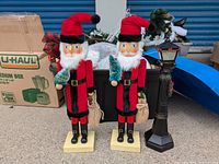 Pair of standing nutcracker decorations with red hats, black boots, and holding a small sack each