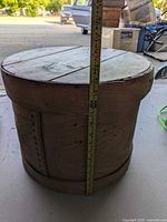Full view of the wooden cheese barrel with measuring tape showing height of approximately 13.5 inches.