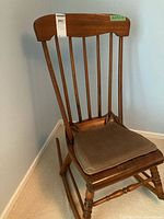 View of the rocking chair showing the full side profile, back rest slats and cushion.